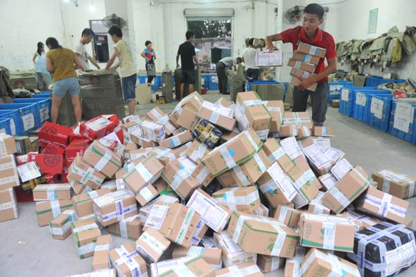 Workers at a delivery service sort parcels in Hangzhou, Zhejiang province. China is set to further open its express delivery market to foreign companies.HU JIANHUAN/CHINA DAILY  