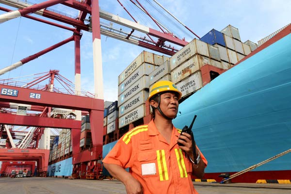 A worker directs container loading operations at the Qingdao Port in Shandong province. Fraudulent trade activities, which once involved the port, have seriously distorted foreign trade data, said the national foreign exchange regulator on Thursday. YU FANGPING/CHINA DAILY  