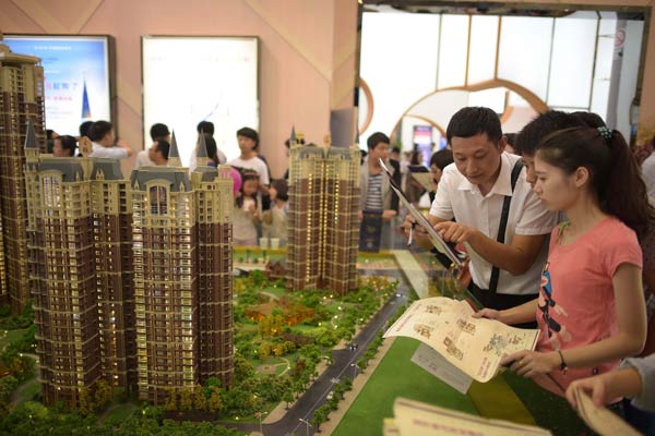 Potential homebuyers visit a housing expo in Chengdu, Sichuan province, on Oct 1, 2014, the first day of the seven-day National Day holidays. Analysts said a significant rebound in home sales is on the way after the central bank eased housing credit conditions. XUE YUBIN/XINHUA  