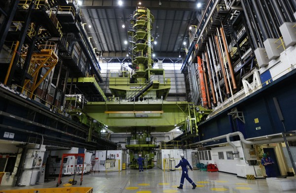 An employee walks through the charge hall inside EDF Energy's Hinkley Point B nuclear power station in Bridgwater, south-west England. Experts said the Hinkley Point C project, in which two Chinese nuclear giants hold a minor stake, will pave the way for Chinese companies eventually owning a nuclear project in the UK. [Provided to China Daily]