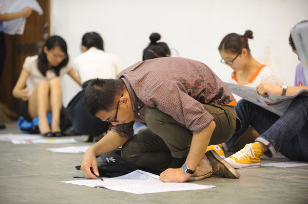 A college graduate looks at a job listing during a job fair on June 7 in Hangzhou, capital of Zhejiang province. The fair was exclusively for 2014 college graduates. [Provided to China Daily]  