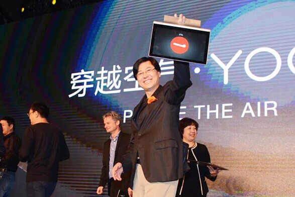 Yang Yuanqing, chairman and chief executive of Lenovo Group Ltd, holds aloft the company's newly launched tablet Yoga in Beijing on Friday. The company hopes the new products will attract more high-end users. [Provided to China Daily]  