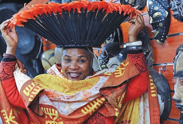 A businesswoman from Cameroon in traditional costume tries to attract customers at the Yiwu International Trade Mart. [Photo/Xinhua]  