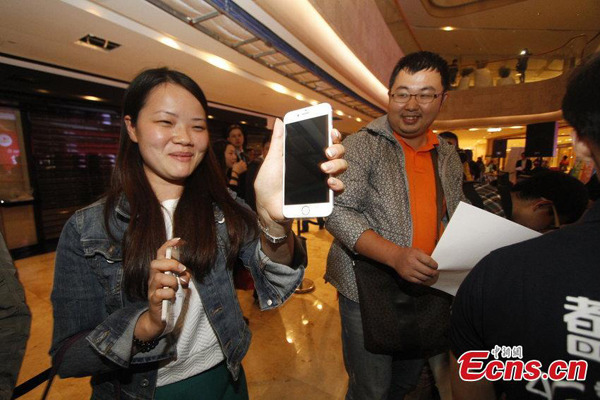 A girl poses with her iPhone 6 outside an outlet of China Mobile in Nanjing, Jiangsu province after the devises go on sale on Chinese mainland on Friday morning, October 17, 2014. Apple fans chose to queue up in front of outlets of China Telecom, China Mobile, and China Unicom across the country on Thursday night, waiting for the midnight debut of iPhone 6 handsets. [Photo/CFP] 