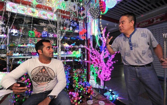 Pakistani businessman Hroon (L) talks with Chinese businessman Li Huaqian at the Small Commodity City of China in Yiwu, East China's Zhejiang province, Sept 23, 2014. Xinhua