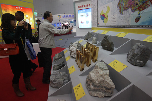 Some participants in the 2014 China Mining Congress and Expo, which opened on Oct 21 in Tianjin, take snapshots of the minerals on display. [Provided to China Daily]  