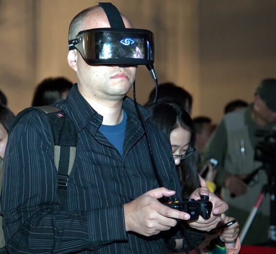 A visitor plays with the Three Glasses, a virtual reality helmet, at a press conference on Oct 24, 2014 in Beijing.[Photo provided to chinadaily.com.cn]
