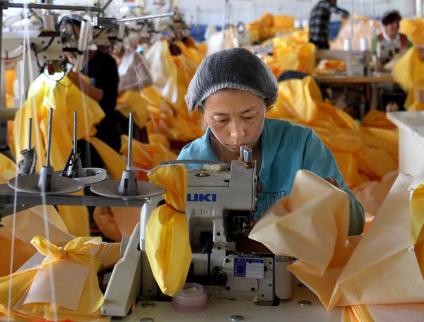 Workers race against time to produce protective suits at the Lakeland Industries factory in Anqiu, Shandong province, on Tuesday.WANG ZHUANGFEI / CHINA DAILY  