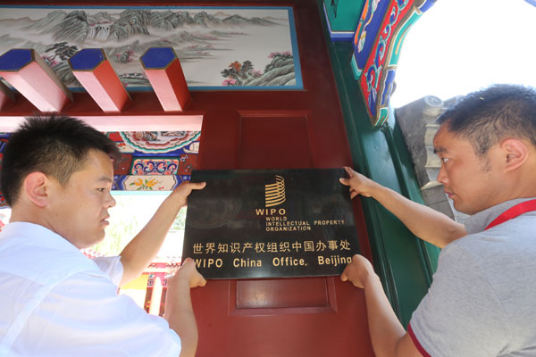 Employees fix the signboard of WIPO China Office during its inauguration on July 10. (Dai Bing / China Daily)