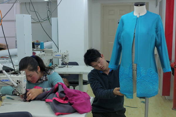 Workers at the Beijing Institute of Fashion Technology prepare traditional Chinese-style outfits for participants in the 22nd Asia-Pacific Economic Cooperation Economic Leaders' Meeting held on Monday and Tuesday in Beijing. [Provided to China Daily]