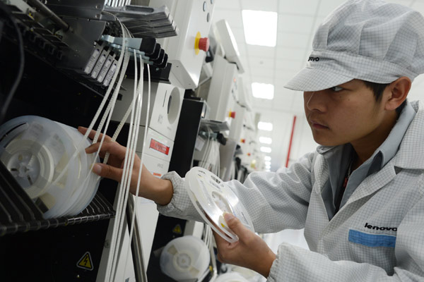 A worker is testing the chips at a workplace of Lenovo Group in Wuhan, capital of Hubei province. The company recently closed two multi-billion-dollar buyouts of IBM Corp's x86 server unit and Motorola Mobility. [Zhao Chao / China Daily]  