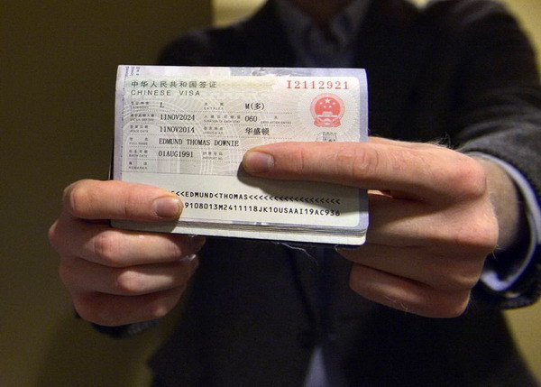 Edmund Thomas Downie shows his visa to the press after becoming the first American citizen to be issued a ten-year visa at the Visa Department of the Chinese Embassy to the United States in Washington D.C., Nov 12, 2014. [Photo/Xinhua]