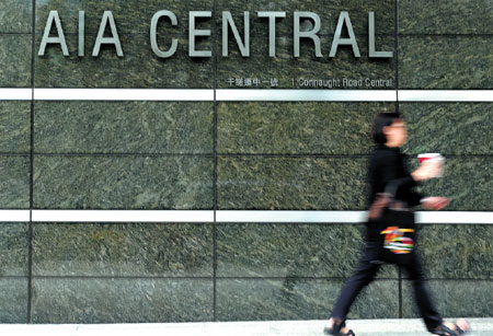 A woman walks past the AIA building in Central, Hong Kong. The life-insurance company operates in 17 markets in the Asia-Pacific region with total assets of $159 billion as of May 31 this year. (Parker Zheng / China Daily)