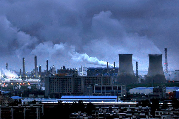Smoke and vapor discharged from chimneys and condensing towers in a refinery in Ningbo, Zhejiang province. More Chinese enterprises are facing pressure to cut emissions. [Photo/ Provided to China Daily]  