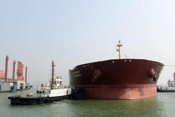 An oil tanker gets ready to unload cargo at the port in Rizhao, Shandong province. An expert said China should take advantage of falling crude prices to build up its strategic oil reserves. [Chen weifeng / China Daily]  