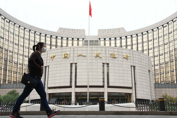 A woman walks outside the headquarters of the People's Bank of China in Beijing. The central bank will maintain a prudent monetary policy, said Hu Xiaolian, its deputy governor. [Wang Yueling / China Daily]  
