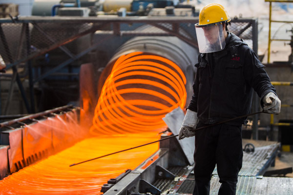 An employee putting finishing touches to steel products for export at a workshop in Lianyungang, Jiangsu province. State-owned industrial enterprises' profit fell 1.2 percent year-on-year from January to October, while the profits of private companies rose 8.7 percent. [Si Wei / China Daily]  
