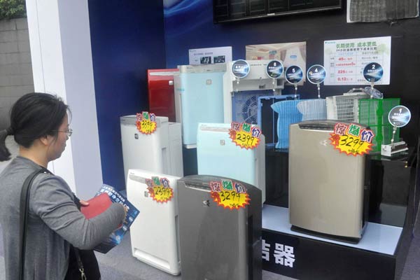 A customer checks out air purifiers at a store in Shanghai. Xiaomi Corp will launch an air purifier that can be remotely turned on using a smartphone. YAN DAMING/CHINA DAILY  