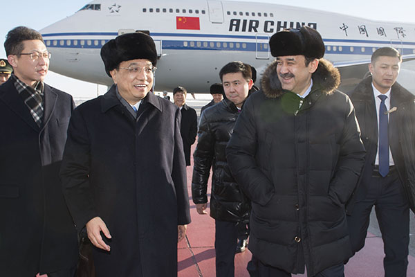 Premier Li Keqiang is welcomed by his Kazakh counterpart Karim Masimov at the Astana airport on Sunday. HUANG JINGWEN / XINHUA  