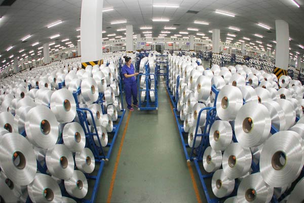 A worker conducting routine checks at a spinning workshop of Hengli Group in Nantong, Jiangsu province. [Provided to China Daily]  