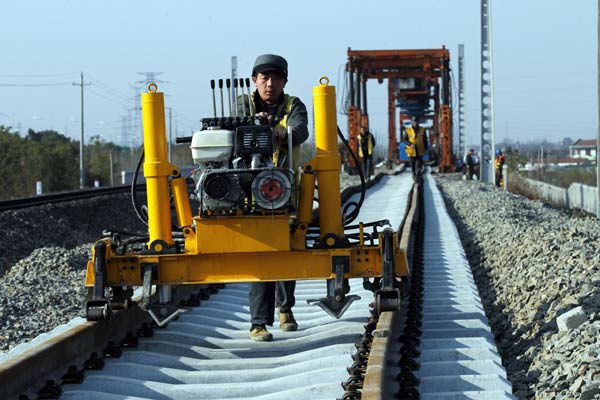 Workers test rail tracks on the Nantong section of the Nanjing-Qidong railway in Jiangsu province. The country's fixed-asset investment is expected to reach 59.4 trillion yuan ($9.6 trillion) in 2015. [Photo by XU CONGJUN/CHINA DAILY]  