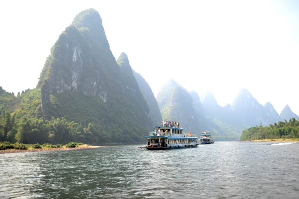 Tourists travel on the Lijiang River in Guilin, Guangxi Zhuang autonomous region. Local tourist officials say the river boat tour program will be upgraded to use better boats. [Photo/Xinhua]