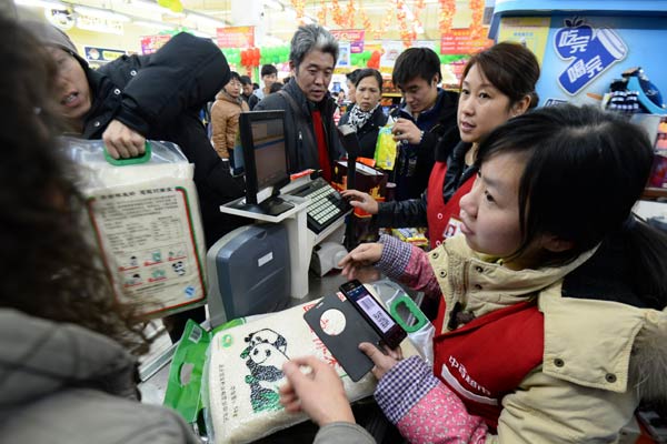 Customers check out at a supermarket in Wuhan, Hubei province. Retail sales in November reached 230 billion yuan ($37.16 billion), up 11.7 percent year-on-year, according to the Ministry of Commerce. JIN SILIU/CHINA DAILY