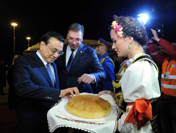 Premier Li Keqiang is welcomed by Serbia's Prime Mini ster Aleksandar Vucic and a traditional ceremony for distinguished guests upon his arrival at Belgrade, Serbia, on Monday. RAO AIMIN / XINHUA