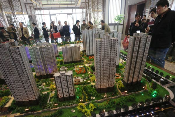 Customers check out a model of a housing project in Hangzhou, Zhejiang province. The rate cuts by the central bank last month have helped change sentiment among prospective buyers. ZHU YINWEI/FOR CHINA DAILY  