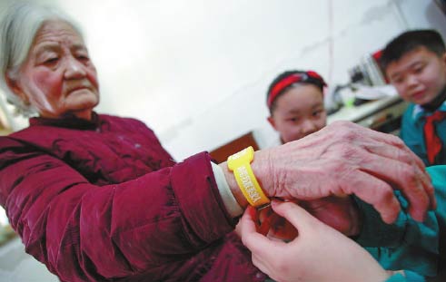 An elderly woman at a senior care home in Jinan, Shandong province, wears a bracelet that has her information in case she gets lost.[Provided to China Daily]  