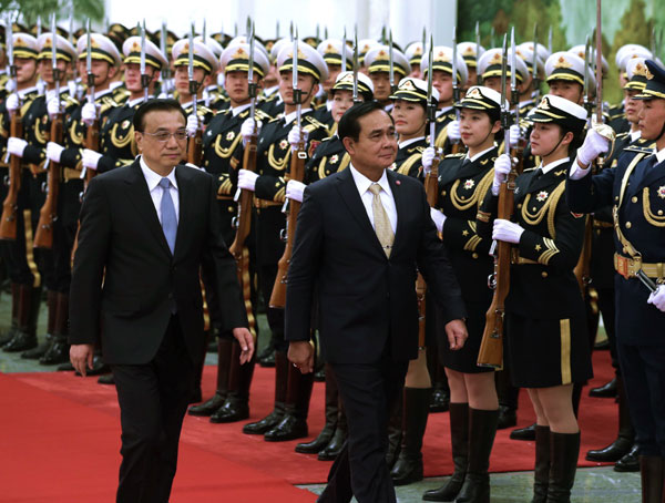 Premier Li Keqiang and Thai Prime Minister Prayut Chan-o-cha inspect a guard of honor during a welcoming ceremony in Beijing on Monday. The two countries signed four deals to carry economic ties forward. WU ZHIYI/CHINA DAILY