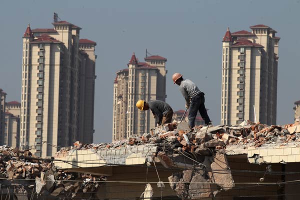 Workers demolish an old building in Nantong, Jiangsu province. Provisional rules for a unified national property registry were released on Monday, ending a system overseen by various agencies. XU CONGJUN/FOR CHINA DAILY  