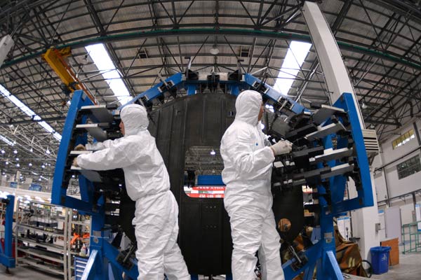 Workers at AVIC SAC Commercial Aircraft Co in Shenyang, Liaoning province, assemble the body part of the C919 passenger airliner.[Photo/Xinhua]