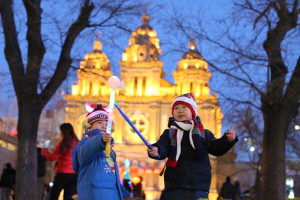 Liu Yuyang (left), 4, and Zhang Yanbo, 5, have fun in Wangfujing, Beijing, on Wednesday night. Many residents of the Chinese capital thronged downtown areas on Christmas Eve. WANG JING/CHINA DAILY
