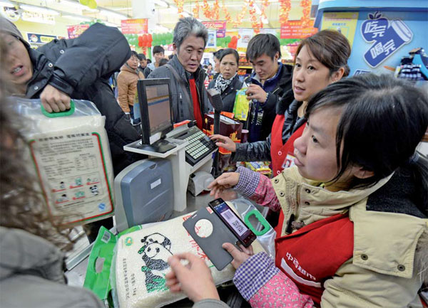 Customers check out at a supermarket in Wuhan, Hubei province. Jin Siliu / China Daily 