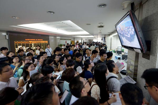 Representatives from property companies check offer prices at a recent land auction in Beijing. The capital city has seen a warm-up in its land market with sales reaching 191 billion yuan ($30.7 billion) this year. Provided to China Daily  