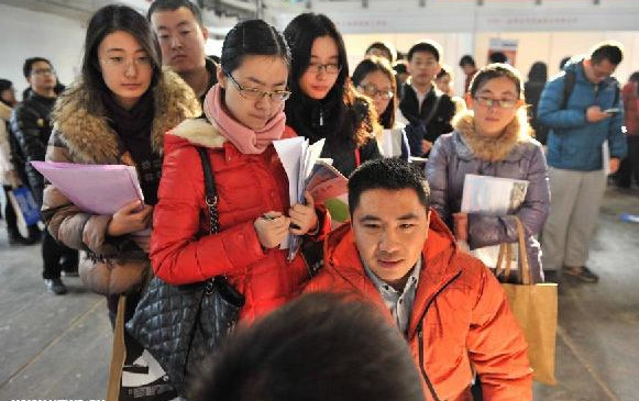 A job seeker receives interview at a job fair for postgraduates in Beijing, capital of China, Dec 18, 2014. About 18,000 opportunities were offered at the fair. [Photo/Xinhua]  