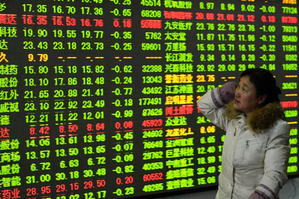 An investor examines stock prices at a brokerage in Hangzhou, capital of Zhejiang province. The Shanghai Composite Index climbed to the highest level since January 2010 on Monday. Expectations of loosening liquidity conditions may further boost market sentiment. LONG WEI/FOR CHINA DAILY  