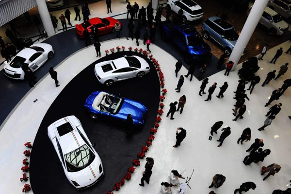 Potential buyers examine imported cars at the International Automobile Mall in Qingdao, Shandong province. Based on the feedback given by PwC and Strategy &, enforcement of the antitrust law will almost certainly have important consequences for the shape and structure of the auto industry in China. [Photo/China Daily]  