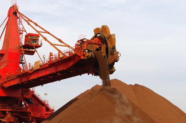 Imported iron ore being unloaded at Rizhao port in Shandong province. A Chinese private company plans to acquire an iron ore mine in Greenland, the first to explore mineral resources in the Arctic region. [Photo/China Daily]