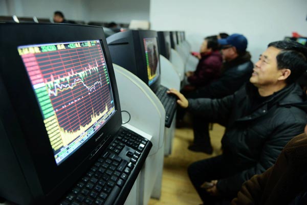 Investors examine share prices at a brokerage in Qingdao, Shandong province, on Monday. The benchmark Shanghai Composite Index fell 1.71 percent to 3229.32 points, down from the five-year high of 3404.83 on Friday. [Photo/China Daily]