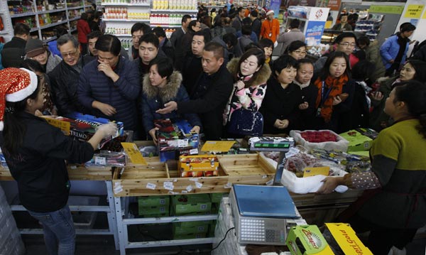 Shoppers buy imported fruit at a shop in the China (Shanghai) Pilot Free Trade Zone. China has signed 12 free trade agreements with countries or regional blocs. [Photo/Xinhua]