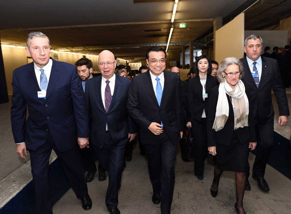 Premier Li Keqiang, flanked by other officials, including Klaus Schwab, founder and executive chairman of the World Economic Forum, enters the meeting venue in Davos on Wednesday. Rao Aimin / Xinhua   