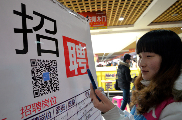 A job hunter scans the code at a recruitment fair in Handan, Hebei province. Job ads are being seen more frequently in social media such as micro blogs and WeChat, in recent years.[HAO QUNYING/CHINA DAILY]