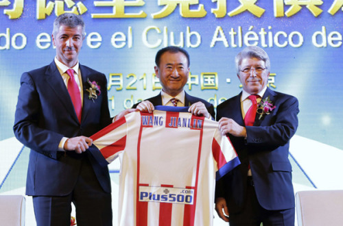 Wang Jianlin (C), chairman of Dalian Wanda Group, holds an Atletico Madrid jersey with his name, to pose for a photo with Atletico Madrid's President Enrique Cerezo (R) and managing director Miguel Angel Gil after a signing ceremony in Beijing, Jan 21, 2015. [Photo/Agencies]