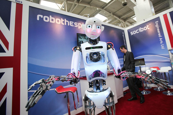 An employee from a British company displays a humanoid robot at the CeBIT exhibition in Hanover, Germany on March 11, 2014. [Photo/Xinhua]