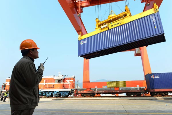 Containers are loaded on the first train heading for Madrid, Spain, at the railway freight transport station in Yiwu, Zhejiang province. The amount of goods carried on China's rail network declined in 2014 compared with the previous year, despite fixed-asset investment in the railways hitting a record four-year high. [Photo/China Daily] 