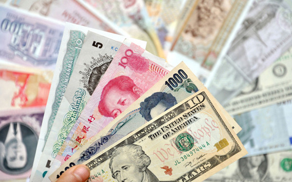 Foreign currencies are placed next to 100 yuan banknote. [Photo/ China Daily]