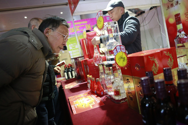 A visitor inspects liquor products at a recent wine and spirits trade fair in Wuhan, capital of Hubei province. Apart from Moutai, which saw 2 percent growth in its market value, all the shortlisted baijiu brands witnessed a significant decline in their market value in 2014. [Photo provided to China Daily]