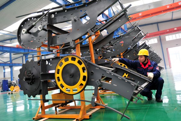 A worker checks an elebator component at a high tech industry zone in Yichang, Hubei province. China's manufacturing Purchasing Managers Index in January weakened to a 28-month low of 49.8 from 50.1 in December. [Zhang Guorong/China Daily]